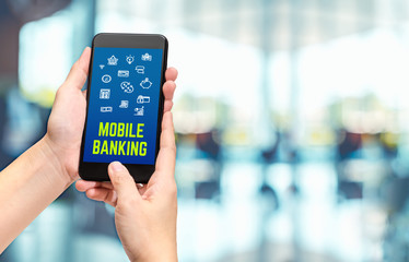 Poster - Hand holding mobile with mobile banking apps on smartphone screen at cafe restaurant,Digital lifestyle,modern financial business concept.