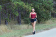 Young woman running on forest trail to lose weight and maintaining healthy life.