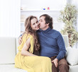 © yurolaitsalbert - portrait of beautiful couple sitting on the couch in the living room.
