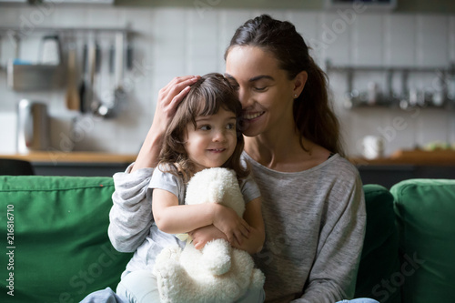 Fotomural Happy single mother hugging cute daughter showing care support, young smiling mo