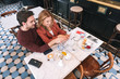 © zinkevych - Romantic restaurant. Top view of loving attractive couple choosing meal and pointing at menu