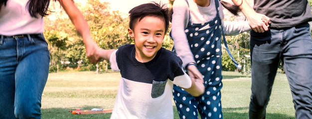 Boy playing with family having fun in summer park