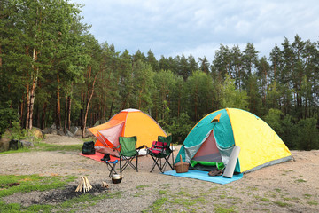 Camping tents and accessories in wilderness on summer day