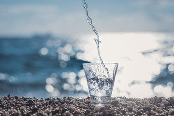 Wall Mural - splashing water in a glass by the sea