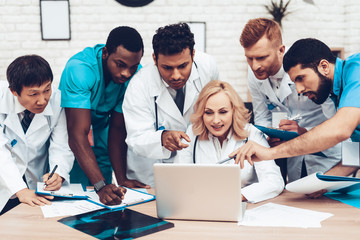 Wall Mural - Hospital Multinational Doctors Looking On Laptop.