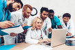 © VadimGuzhva - Hospital Multinational Doctors Looking On Laptop.