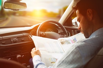 Poster - Man sitting in car and looking at road map 