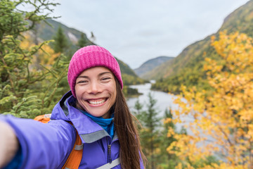 Wall Mural - Selfie Asian girl hiking in autumn nature mountain camping outdoor fall lifestyle. Woman taking photo with mobile phone online.