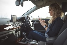 Female Executive Using Mobile In The Car
