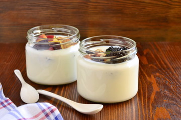 Wall Mural - Homemade yogurt in small jars with berries, fruits, almonds