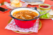 Traditional Hungarian fish soup in a small red kettle