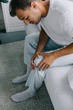 © LIGHTFIELD STUDIOS - high angle view of man in pajamas suffering from knee pain while sitting on bed