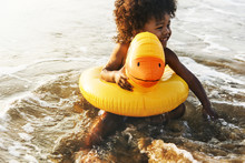 Cute Toddler With Duck Tube On The Beach
