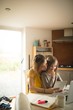 © Wavebreak Media - Mother with daughter sitting on chair using digital tablet in