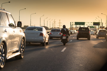 Traffic jam on a hot summer evening. Highway and road junction. Sunset cars and moto