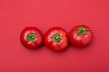 red tomatos on color background