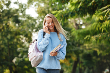 Wall Mural - Portrait of a smiling young girl student with backpack