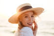© Drobot Dean - Cute blonde woman wearing hat outdoors at the beach