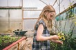 © Wavebreak Media - Side view of girl holding flowers in greenhouse