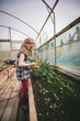 © Wavebreak Media - Side view of girl holding flowers in greenhouse