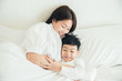 © ic36006 - Happy loving family. Mother and her son playing on the bed in bedroom.