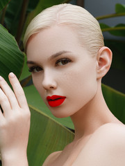 Cosmetics, makeup and trends. Bright lip gloss and lipstick on lips. Closeup of beautiful female face with red lip makeup. Beautiful part of female face. Perfect clean skin in red light