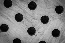 Wooden Washer With Holes For Dishes Shown Close Up. Black And White Photo. Interesting Background.