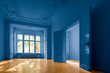 empty room in old apartment building with  parquet floor  and blue painted walls