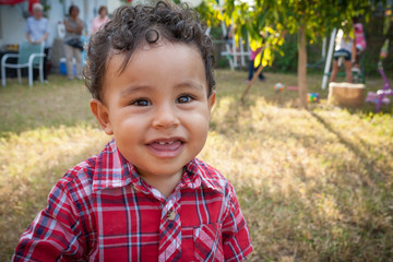 Happy one-year-old boy looking at the camera with a smile.