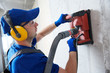 © Kadmy - electrician at work. cutting concrete wall for cabling by diamond slitting machine