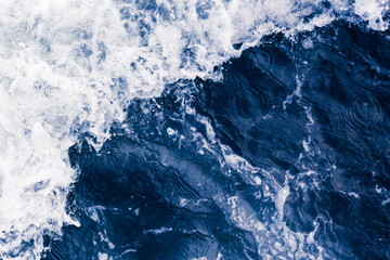 Wall Mural - Beautiful blue sea diagonal wave with white foam and bubbles during high tide, close up