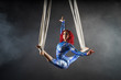 athletic sexy aerial circus artist with redhead in blue costume dancing in the air with balance