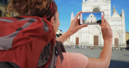 White female exploring Florence taking video of Basilica di Santa Croce 