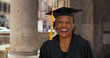 © Mark Adams - Portrait of senior black woman in graduation gown smiling and cheering