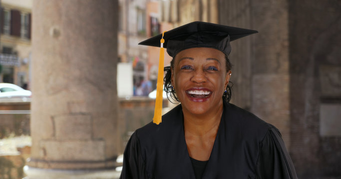 Wall Mural -  - Portrait of senior black woman in graduation gown smiling and cheering