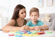© New Africa - Young woman and little boy with autistic disorder playing at home