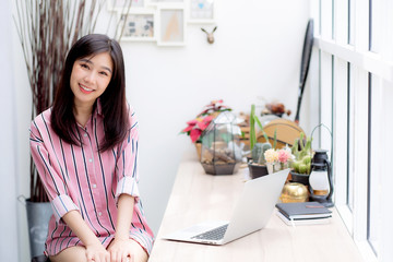 Wall Mural - Beautiful of portrait asian young woman working online on laptop sitting at coffee shop, professional female freelancer using notebook computer with connect to internet for distance job.