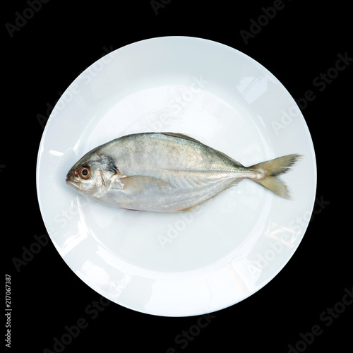 Fotografia, Obraz Yellow Tail Scad fish, Decapterus fish, on White plate, isolated on black backgr