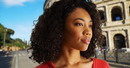 Wall Mural - Relaxed young African woman enjoying atmosphere in street by Roman Colosseum