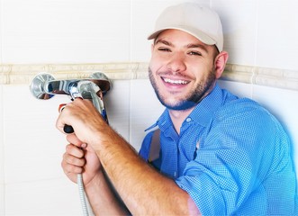 Wall Mural - Plumber working on sink in the small