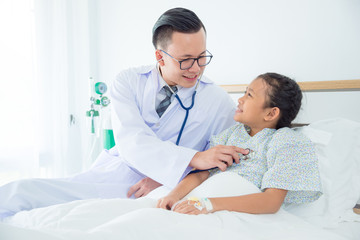 Young Asian male Doctor examining a girl with stethoscope. Medicine and health care concept..