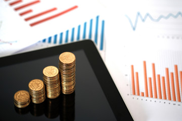 Step of coins stacks with tablet computer and financial graph, business planning vision and finance analysis concept