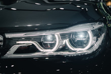 Closeup Headlights Of Modern Car During Turn On Light In Night.