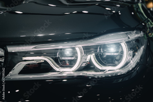 Closeup headlights of modern car during turn on light in night. Canvas Print