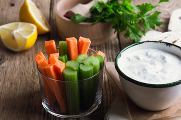 Wall Mural - Yogurt dip with parsley  served  with tortilla chips, carrot, and celery sticks