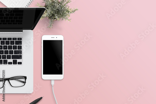 Flat Lay Scene Of Smart Phone And Laptop On Office Desk Pink