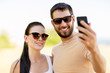 © Syda Productions - technology and people concept - happy couple taking selfie by smartphone in summer