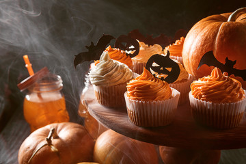 Wall Mural - cupcake and pumpkin on a dark background. sweets for the celebration of Halloween.