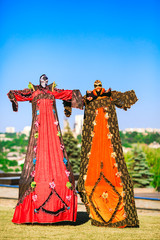 Wall Mural - Young people on stilts posing against the blue sky.