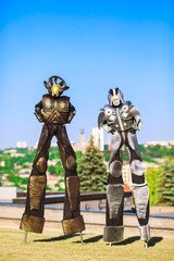 Wall Mural - People in robot costumes pose against a blue sky.